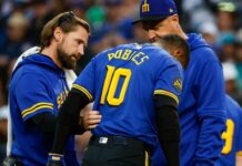 Mariners’ Robles (hand) exits after trying to steal home